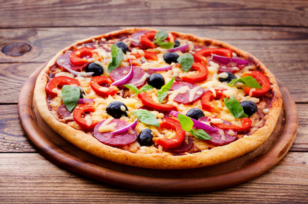 Pizza with ham, pepper and olives  Delicious fresh pizza served on wooden table  Pizza with tomato, salami and olivesの写真素材