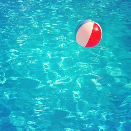 Inflatable colorful ball floating in swimming poolの写真素材