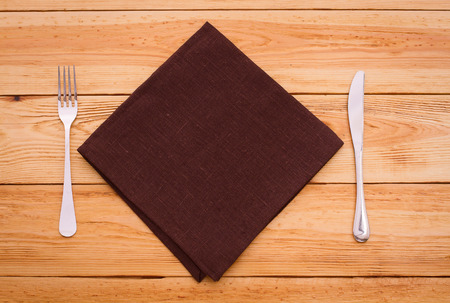 Cutlery on red checkered tablecloth tartan on a wooden table top view. The product page for recipes and menus cookbooksの写真素材