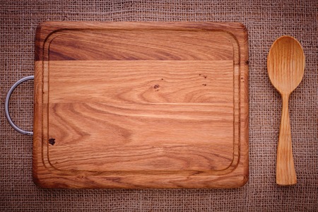 Cutlery on tablecloth burlap sacking wooden table close up view from top wooden kitchen cutting board retro. Product pages for installation recipe books menuの写真素材