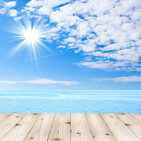 Empty wooden deck table with tablecloth for product montage texture background wallpaper. Blue sea and clouds on sky beach and tropical sea. Stand for product showcase.の写真素材