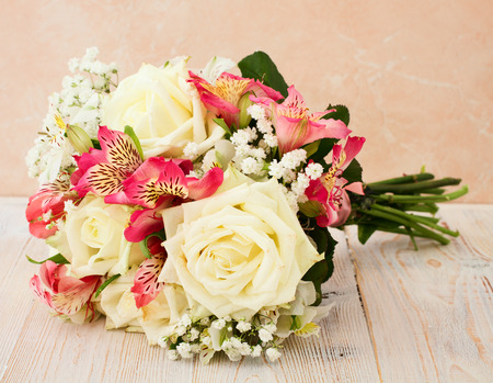 Bridal bouquet of white flowers on wooden surface.の写真素材