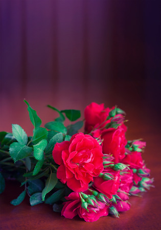 Beautiful bouquet of flowers on wooden table old. Vintage red roses in retro style.の写真素材