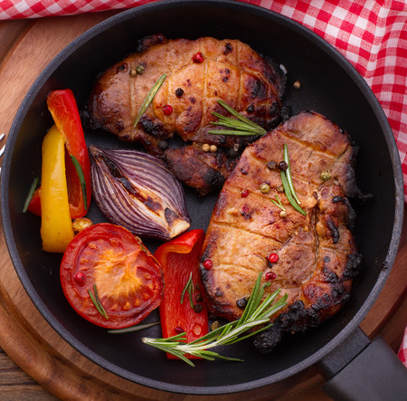 Food meat barbecue with vegetables on wooden surface. Meat steak beef steak bbq tomatoes, peppers spices for cooking meat.の写真素材