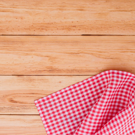Pure notebook for recording menu, recipe on red checkered tablecloth tartan. Wooden table close up...