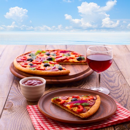 Pizza with ham, pepper and olives. Delicious fresh pizza served on wooden table.の写真素材