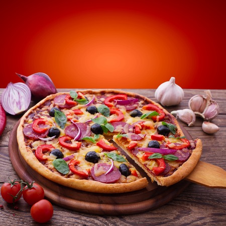 Pizza with ham, pepper and olives. Delicious fresh pizza served on wooden table.の写真素材