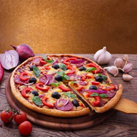 Pizza with ham, pepper and olives. Delicious fresh pizza served on wooden table.の写真素材