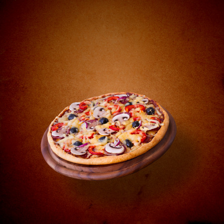 Pizza with ham, pepper and olives. Delicious fresh pizza served on wooden table.の写真素材