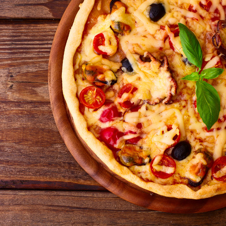 Pizza with seafood. Seafood Italian Pizza slice on wood dish originality. Italian kitchen studio.の写真素材