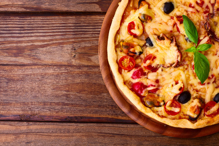 Pizza with seafood. Seafood Italian Pizza slice on wood dish originality. Italian kitchen studio.の写真素材