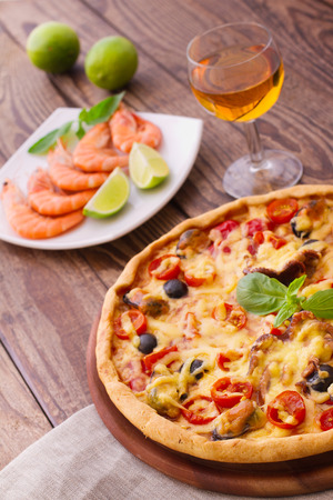Pizza with seafood. Seafood Italian Pizza slice on wood dish originality. Italian kitchen studio.の写真素材