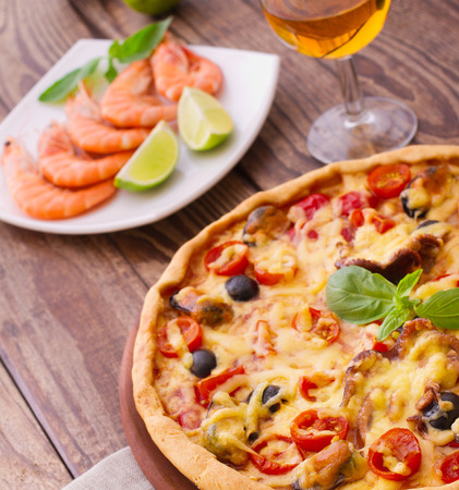 Pizza with seafood. Seafood Italian Pizza slice on wood dish originality. Italian kitchen studio.の写真素材