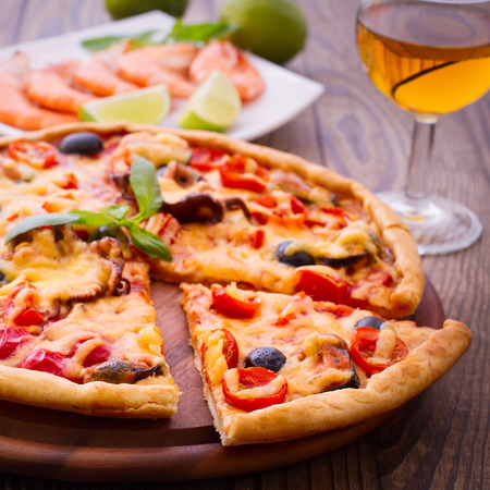 Pizza with seafood. Seafood Italian Pizza slice on wood dish originality. Italian kitchen studio.の写真素材
