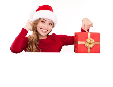 Christmas woman with gift. Santa girl showing your text on a billboardの写真素材