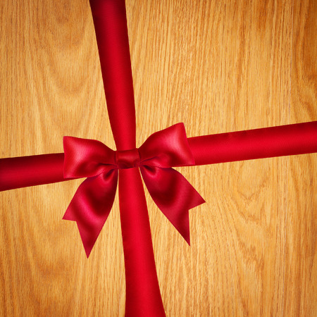 Red ribbon and bow on wooden backgroundの写真素材