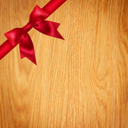 Red ribbon and bow on wooden backgroundの写真素材