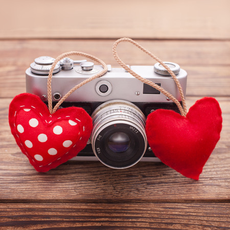 Retro Camera with red hearts on a wooden background. Valentines Day greeting cardの写真素材
