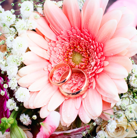 Flowers on wooden surface. Declaration of love, spring. Wedding card, Valentines Day greeting. Wedding rings. Wedding bouquet, background.の写真素材