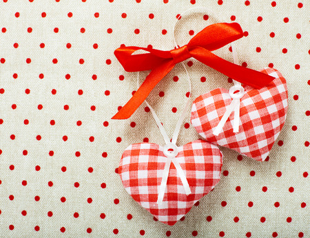 Heart made of cloth in red cell handmade Valentines Day on the background of vintage linen fabric texture. Tag labeling.の写真素材