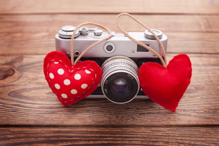Retro Camera with red hearts on a wooden background. Valentines Day greeting cardの写真素材