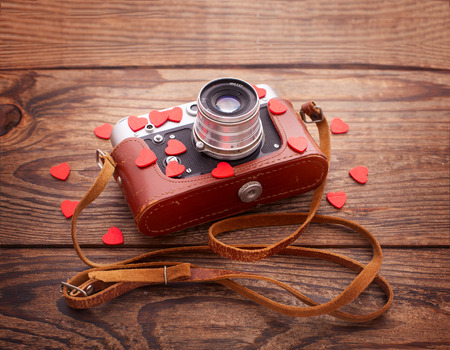 Retro Camera with red hearts on a wooden background. Valentines Day greeting cardの写真素材