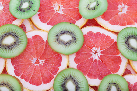 Grapefruit and kiwi rings as background closeup. Stack of citrus piecesの写真素材