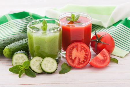 Tomato, cucumber Juices and vegetables on white wooden tableの写真素材