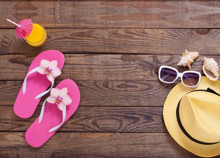 Fashionable clothes sunglasses, hat, flip-flops for beach holiday. Orange juice. Flat mock up for design. Top view. Summer vacation concept.の写真素材