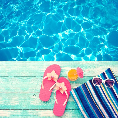 Summer vacation. Pink sandals by swimming pool. Blue sea surface with waves, texture water. Flat mock up for design.の写真素材