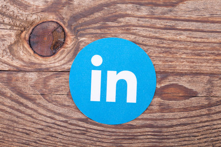 KIEV, UKRAINE - AUGUST 22, 2015: Linkedin logo sign printed on paper and placed on wooden...