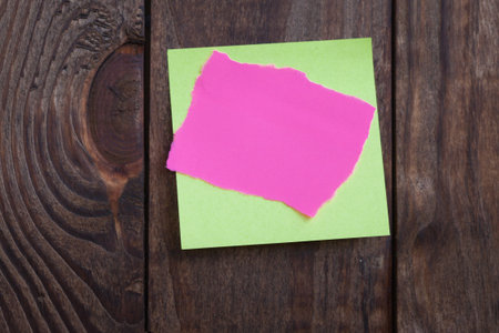 Multicolored paper stickers note on wooden background. Blank forms for workers notes