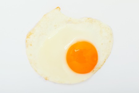 fried egg closeup isolated on white backgroundの写真素材