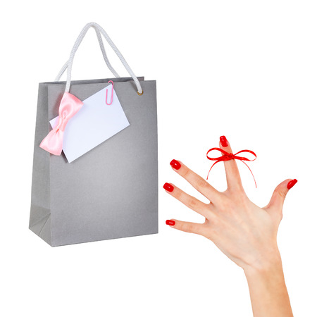 Woman's hand with pink ribbon, card and shopping bag.の写真素材