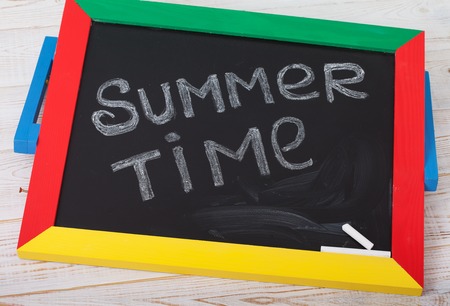 Blackboard with text it's summer time on white wooden deckの写真素材