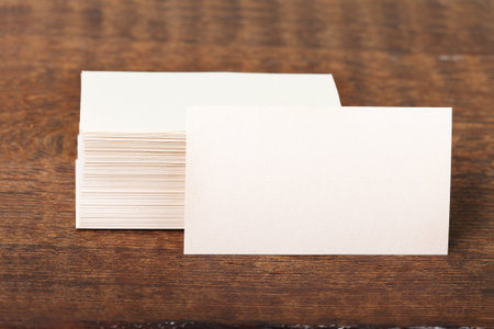 Thick white cotton paper business card mock up on vintage wooden deck. Top view close up