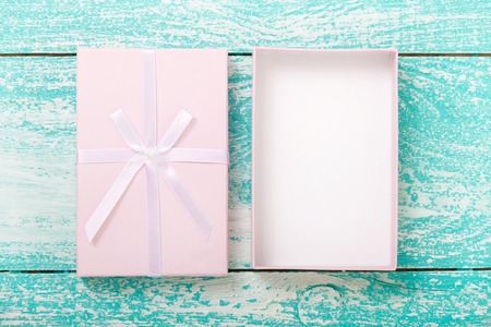 Open gift box on blue vintage wooden desk close up top view.の写真素材