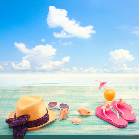 Fashion accessories summer flip flops, hat, glasses on a bright turquoise blue board on the beach. Summer Holidays in Beach Seashore.の写真素材