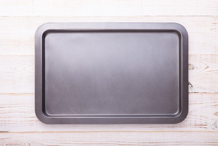 Empty baking tray on white wooden desk close up top view horizontally.の写真素材