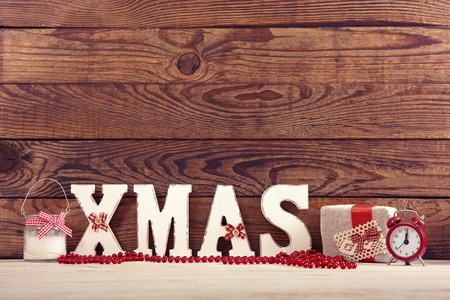 Christmas decorations. Christmas background. Watch, candle and Christmas text on wooden table.の写真素材