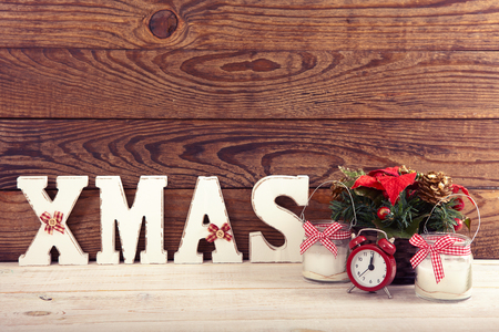Christmas decorations. Christmas background. Watch, candle and Christmas text on wooden table.の写真素材
