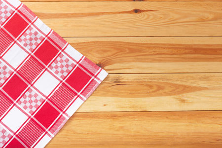 Wooden table covered with tablecloth. Empty tablecloth for product montage. Free space for your...