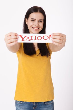 Kiev, Ukraine - August 22, 2016: Woman hands holding the logo of the brand Yahoo icons printed on paper on grey background.のeditorial素材