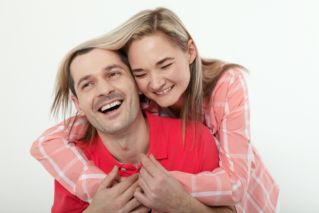 Cheerful young couple at home. Woman and man hugs and kisses.の写真素材