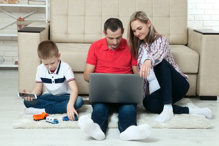 Family having fun chatting on internet with laptop.の写真素材