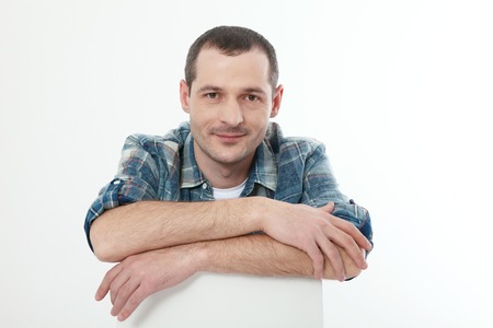Portrait of smart serious handsome man in shirt sitting at homeの写真素材