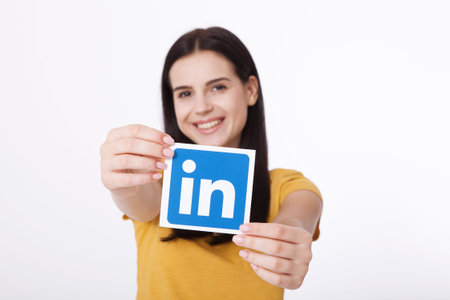 KIEV, UKRAINE - August 22, 2016: Woman hands holding Linkedin icon sign printed on paper on white...
