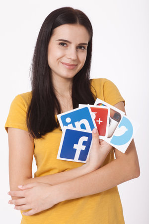 KIEV, UKRAINE - AUGUST 22, 2016: Woman hands holding collection of inscriptions, symbols of popular social media: Twitter, Google, Instagram, Fasebook, Linkedin others printed on paper scattered randomly.のeditorial素材