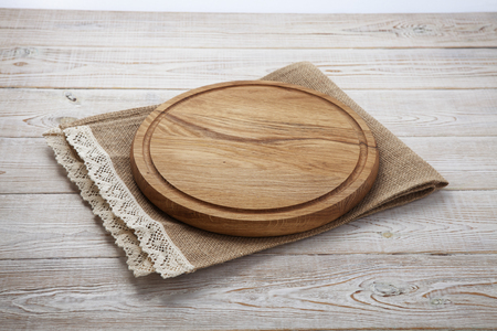 Pizza board and canvas napkin with lace on wooden table. Top view mock upの写真素材