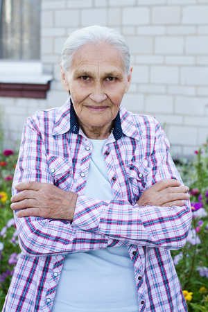 Portrait of smiling elderly woman. A photo on the hause backgroundの写真素材